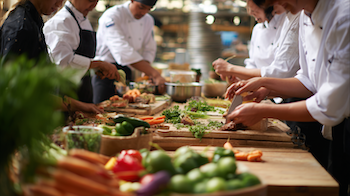 Estudiants de 2n d’Activitats Comercials participant en un taller de cuina amb xefs voluntàries d’AVISMÓN a l’aula gastronòmica del Mercat de Santa Caterina.